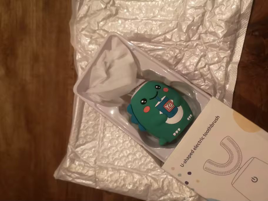 BrushBuddy teal dinosaur handle in its opened box