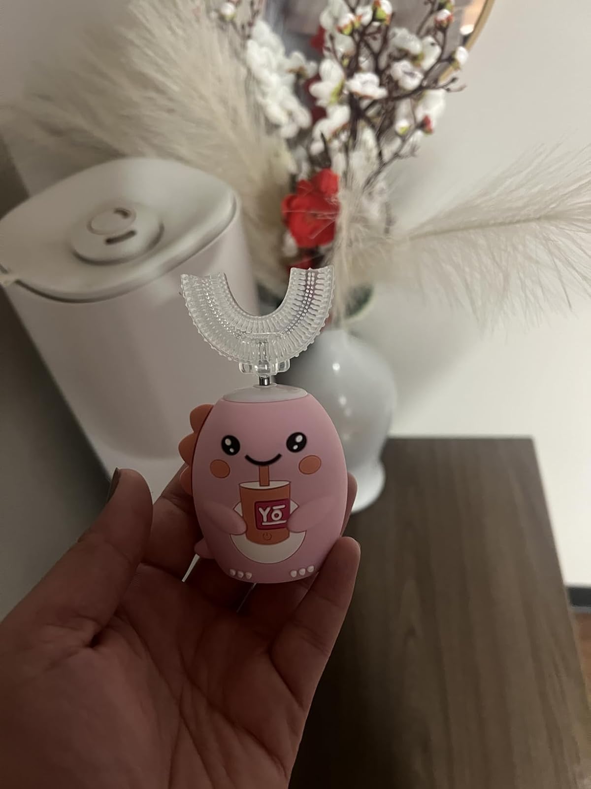 Parent holding the blush pink BrushBuddy with the U-shaped head attached